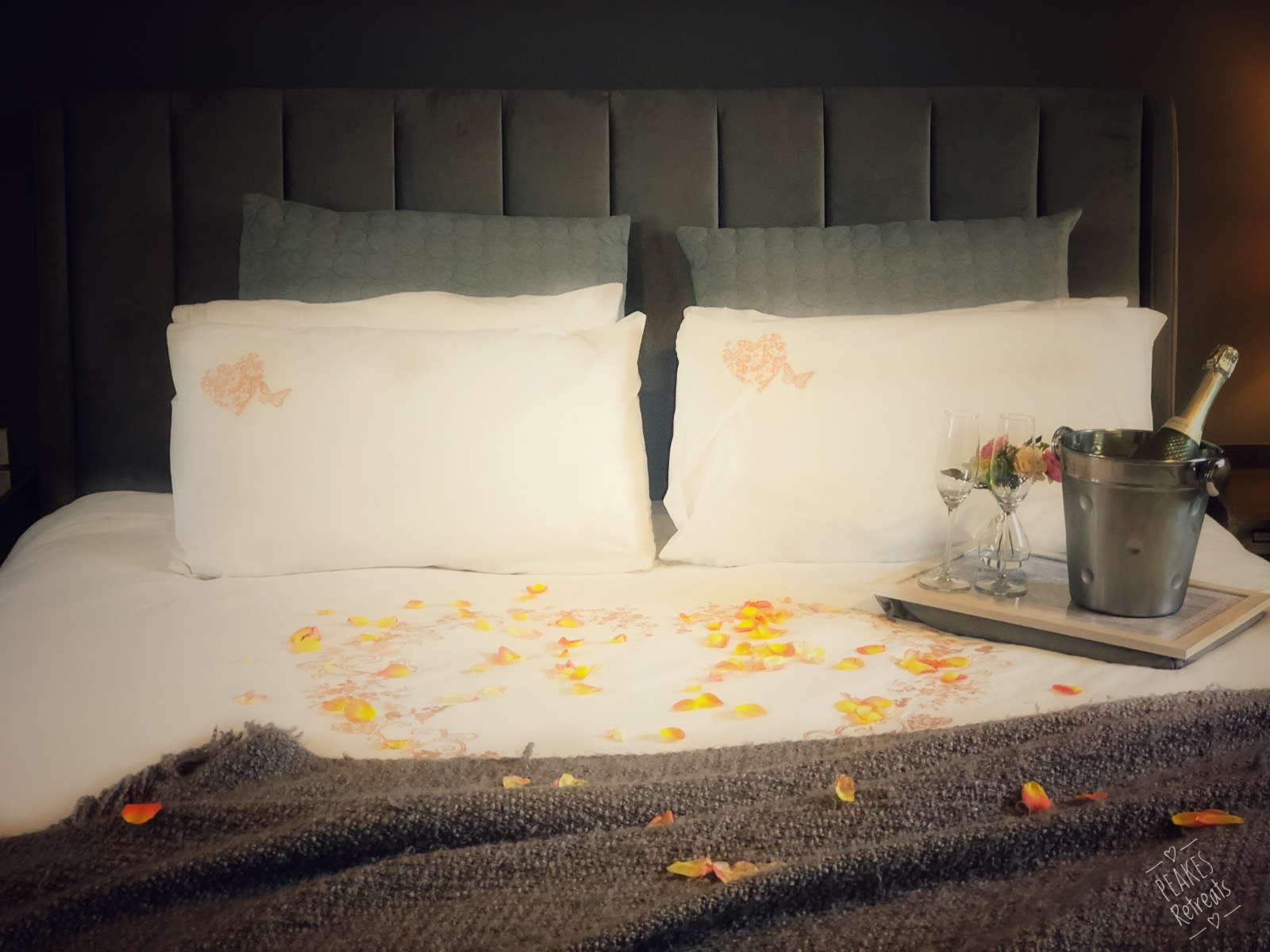 Prosecco and rose petals on superkingsize bed in holiday apartment